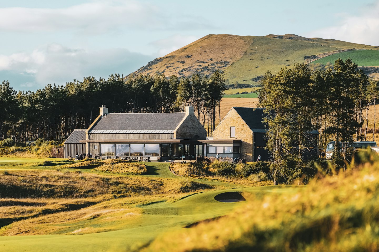 Golf resort building with stone and wood exterior on a golf course.